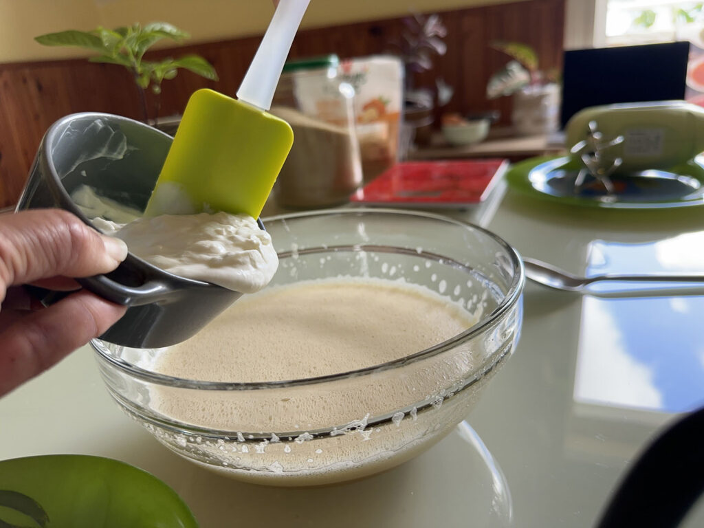 Fromage blanc versé à la maryse dans un saladier contenant les œufs fouettés avec le sucre